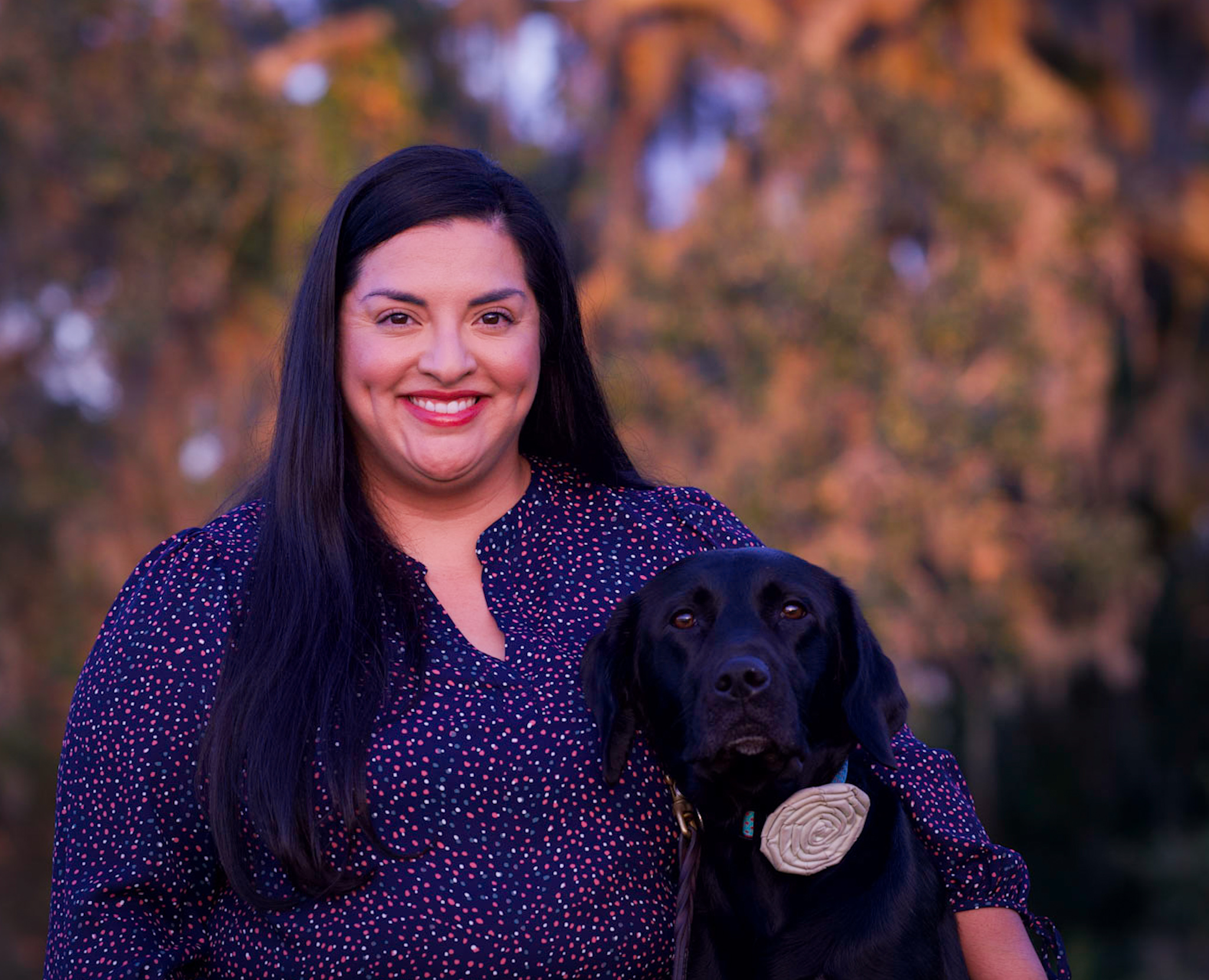 Smiling woman with black labrador